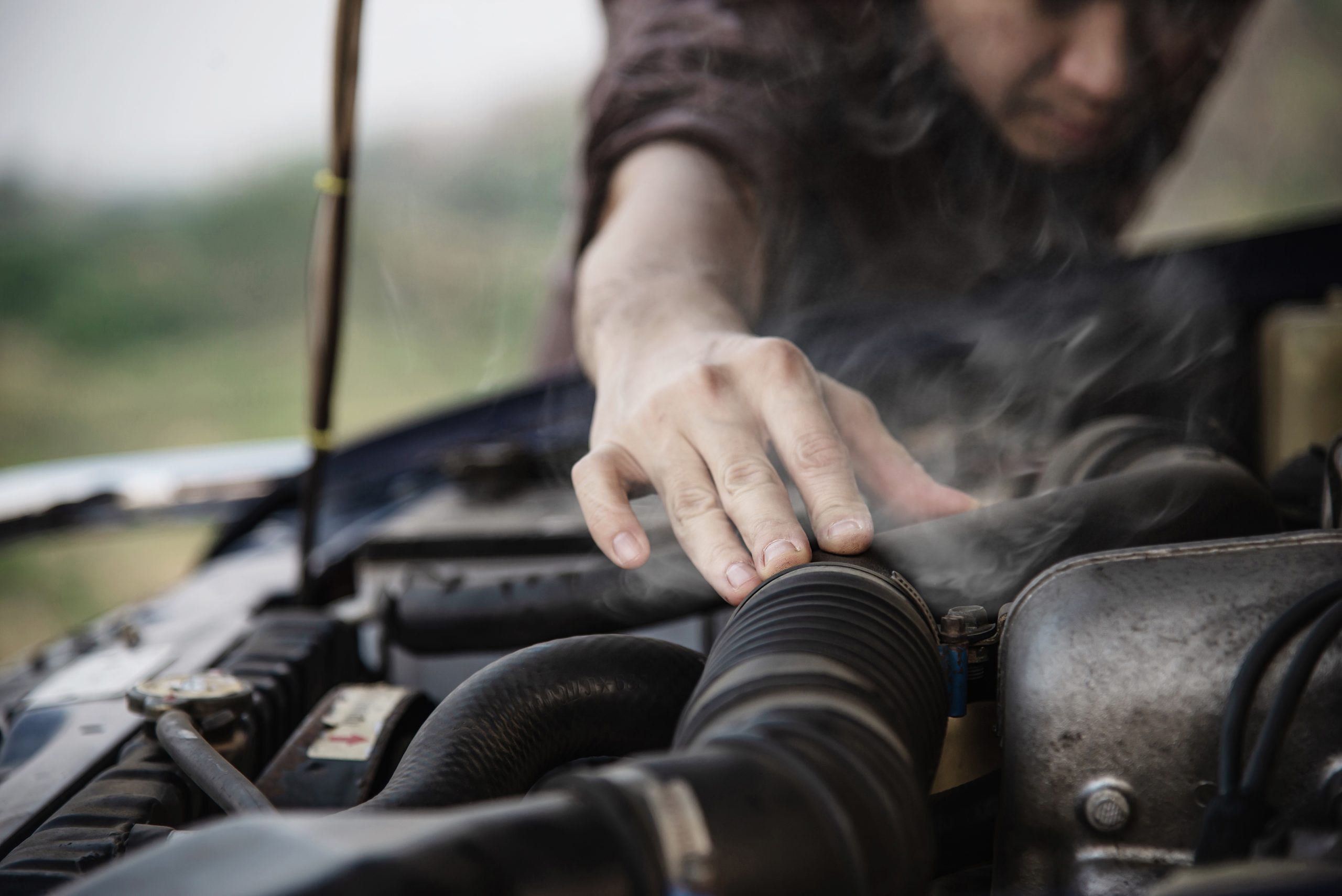 Evite o superaquecimento do motor com as dicas da 2A Automotiva Imagem que mostra um pouco de fumaça em um motor de carro.